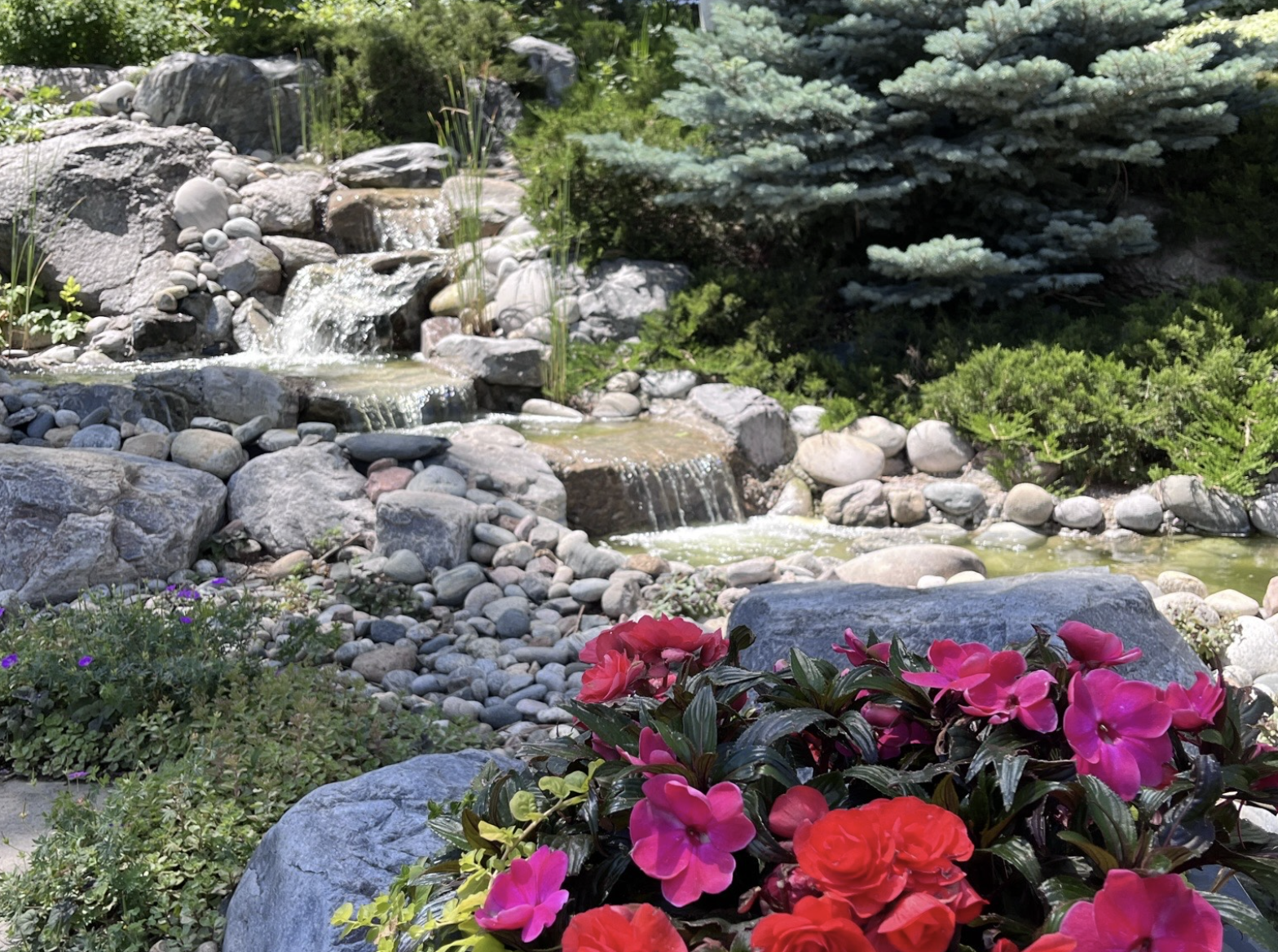 Premium stone patio installation with seating walls and landscape lighting